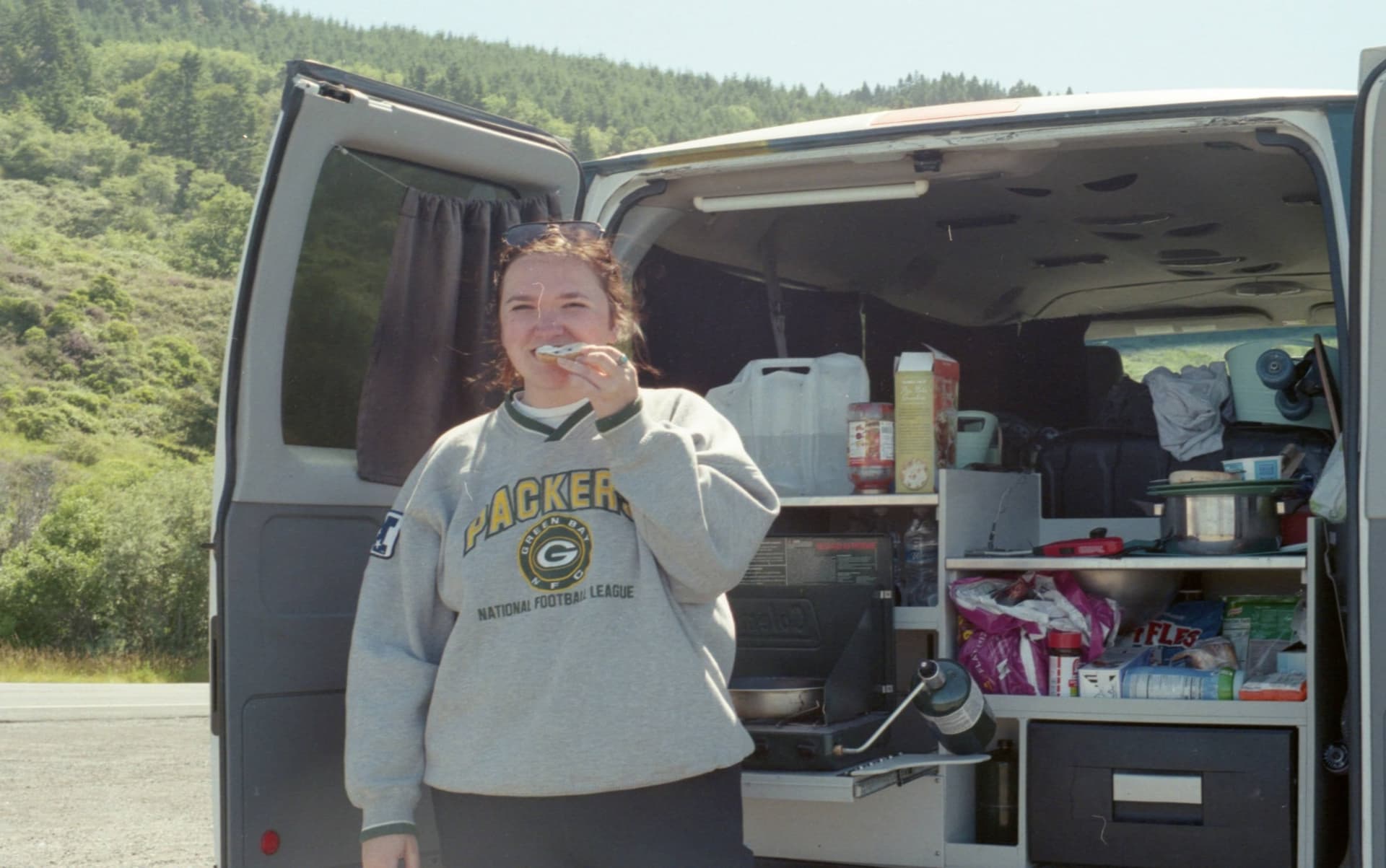 Lauren Nichols eating a snack at the back of a camper van