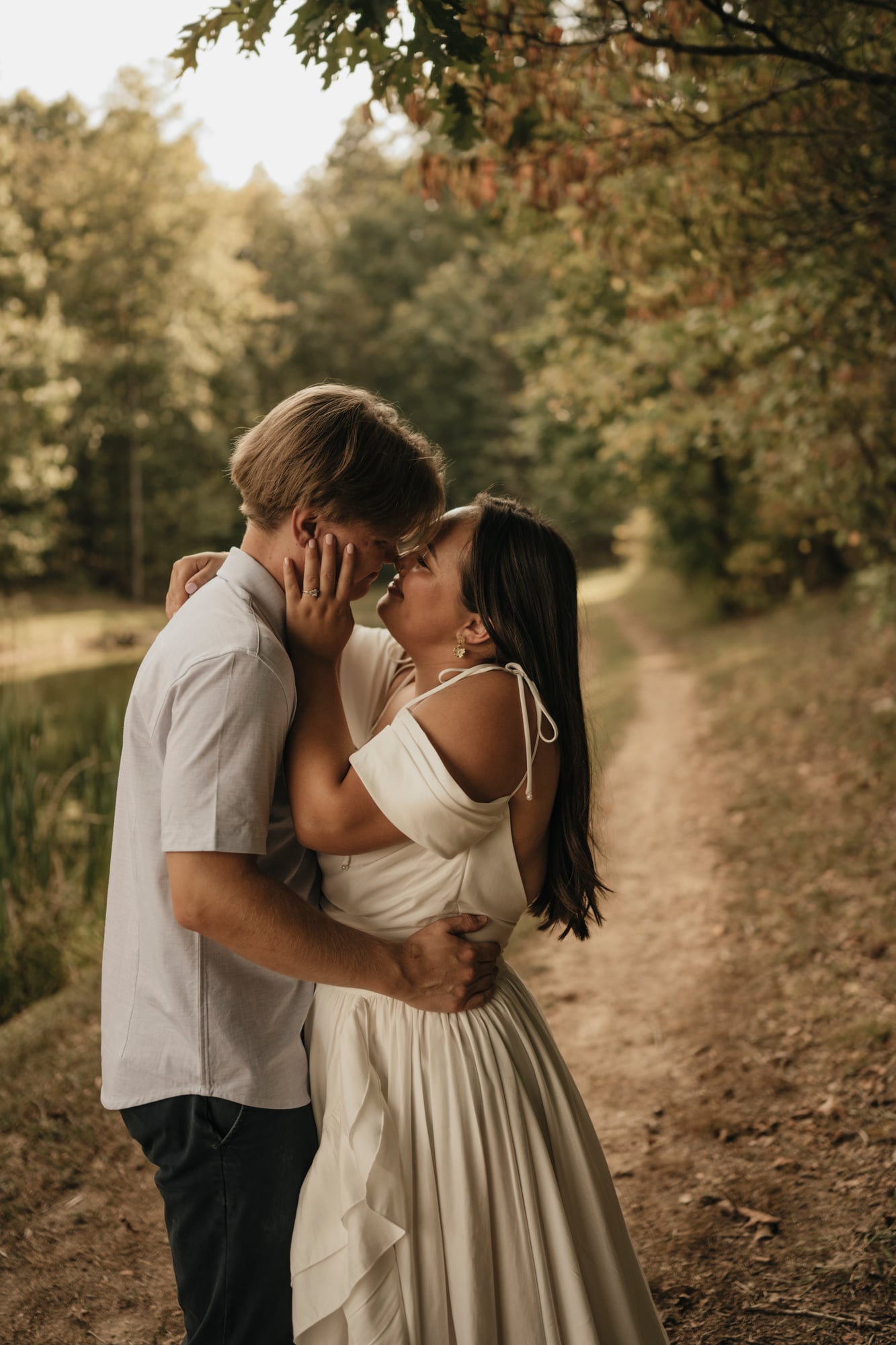 Couple embracing on a forest path at golden hour