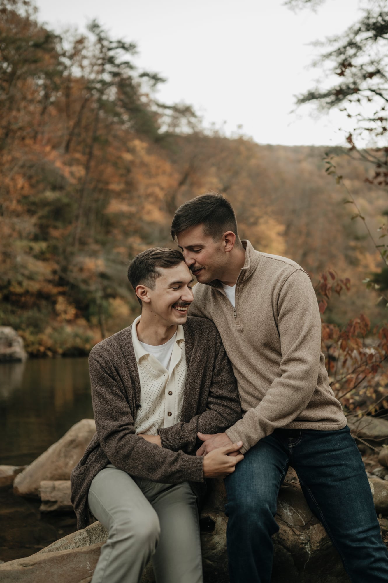 Close portrait of a couple holding hands on rocks by the water