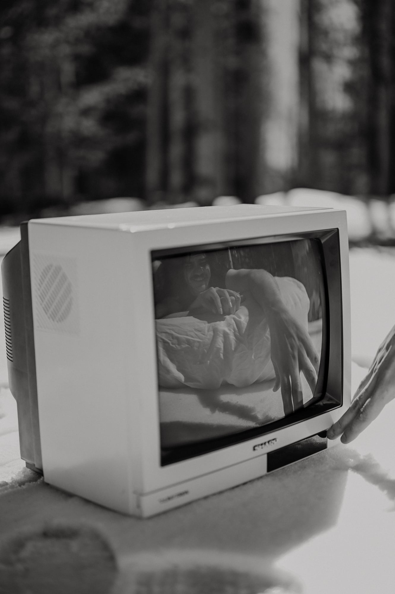Black and white detail of a vintage television showing a couple in the snowy forest