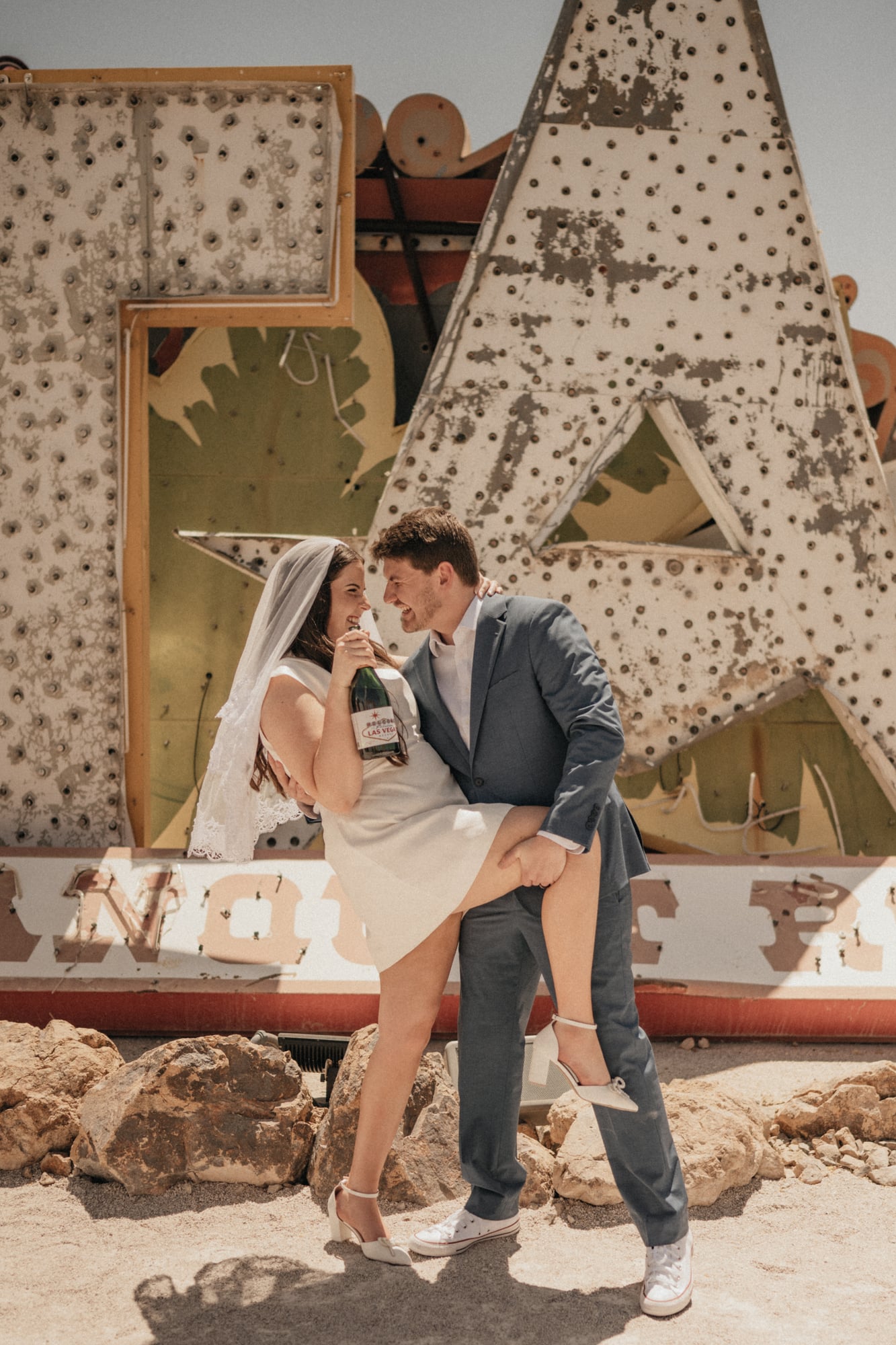 Groom dipping the bride among vintage neon signs at the Neon Museum