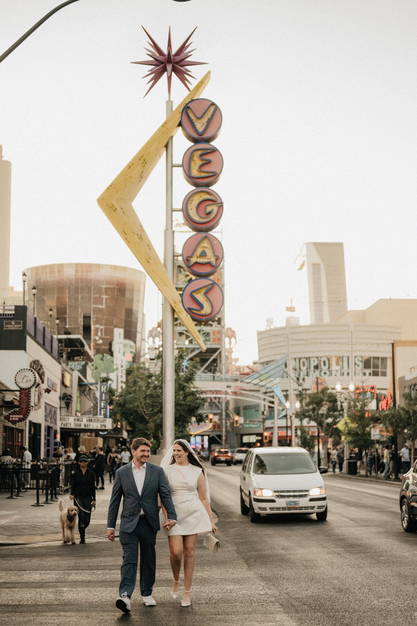 Bride and groom walking hand in hand across a Las Vegas street