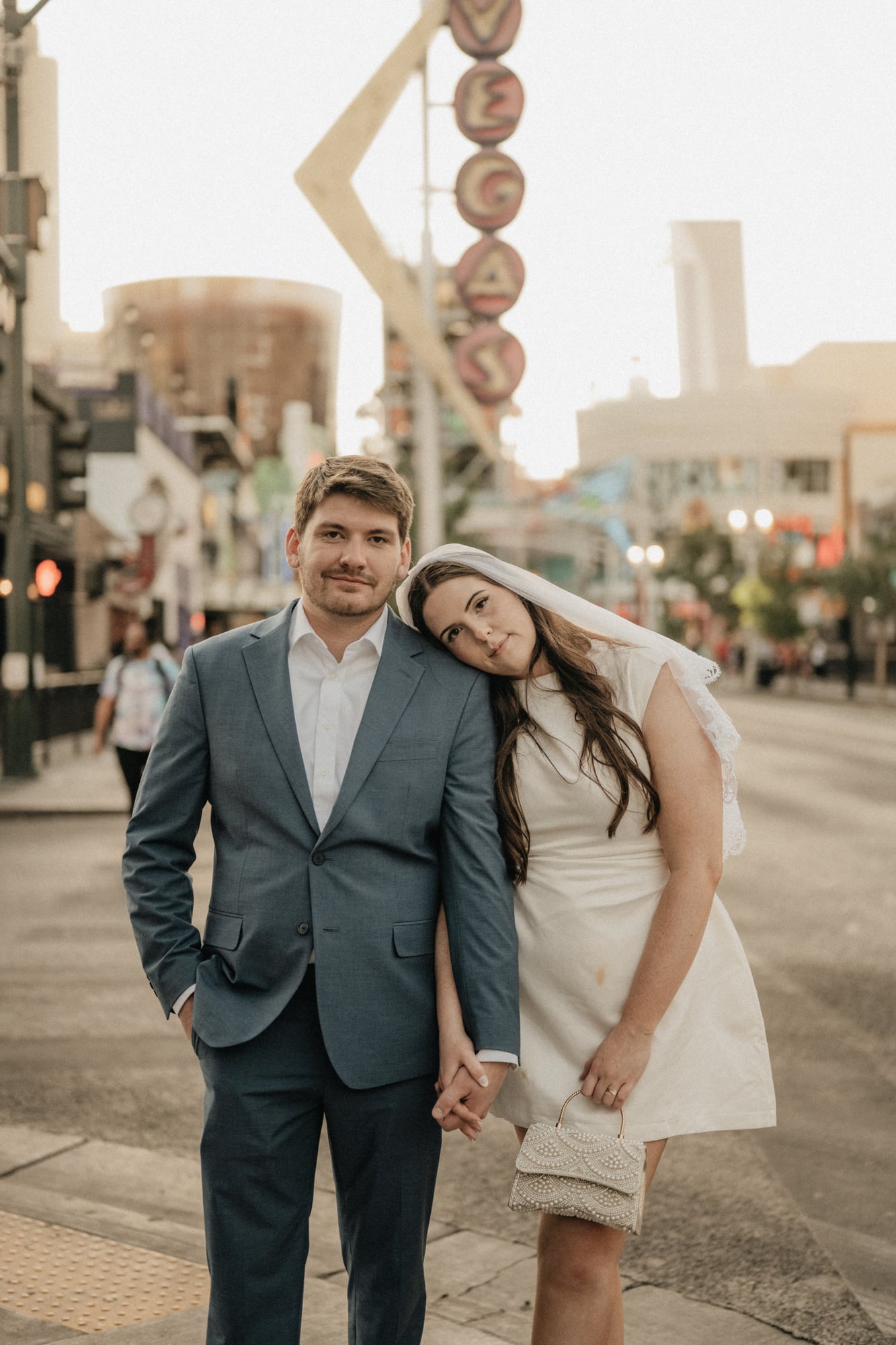Bride and groom posing together with the Vegas neon sign behind them