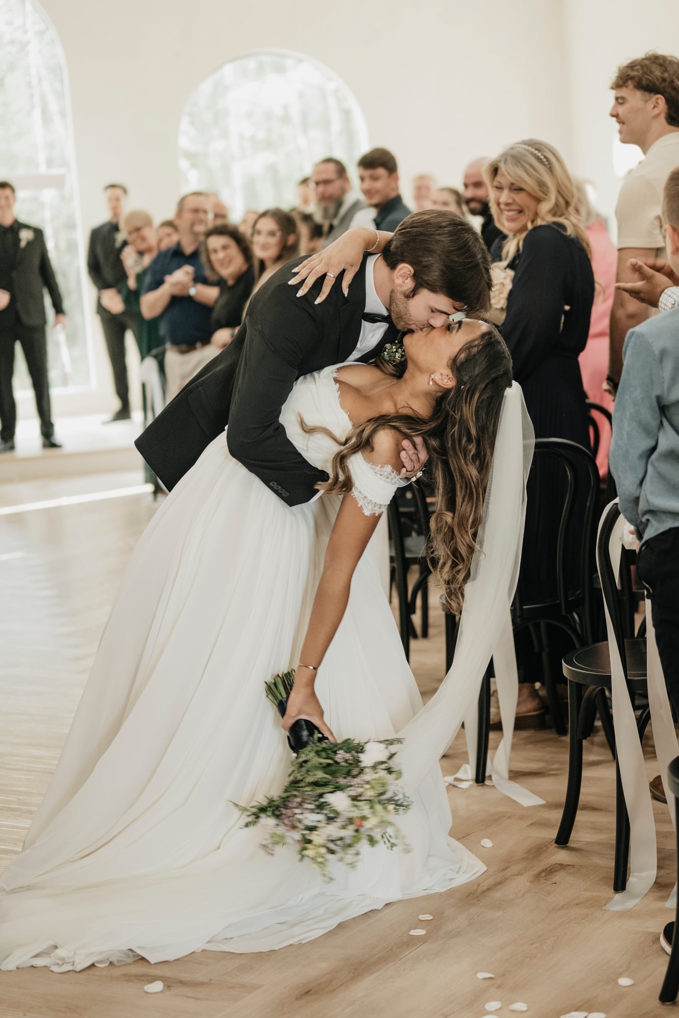 Groom dipping the bride for a kiss at the end of the ceremony aisle