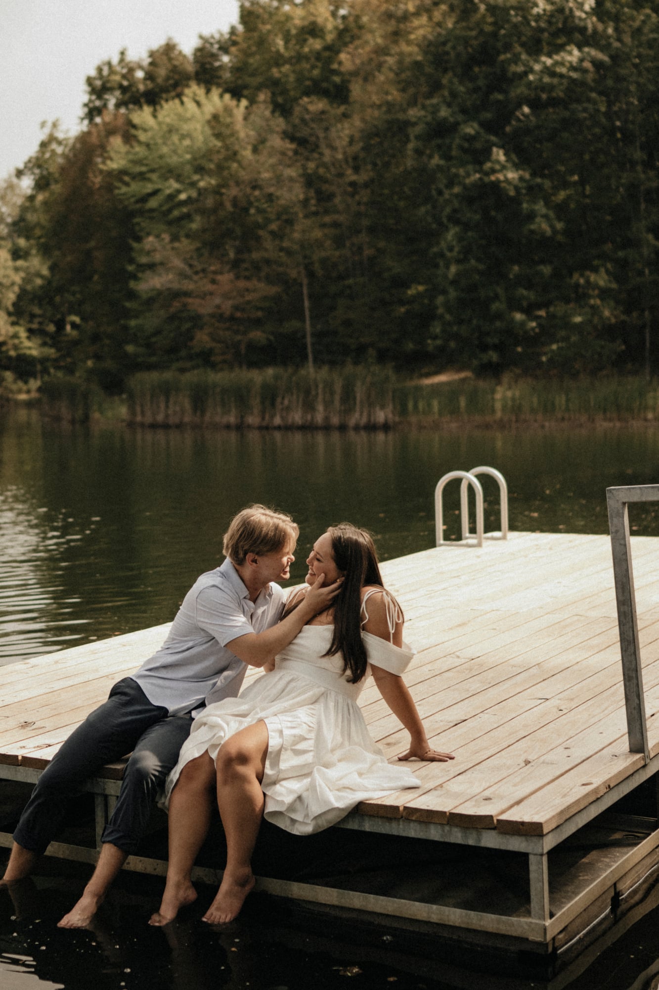 Couple sitting together on a wooden dock over a lake