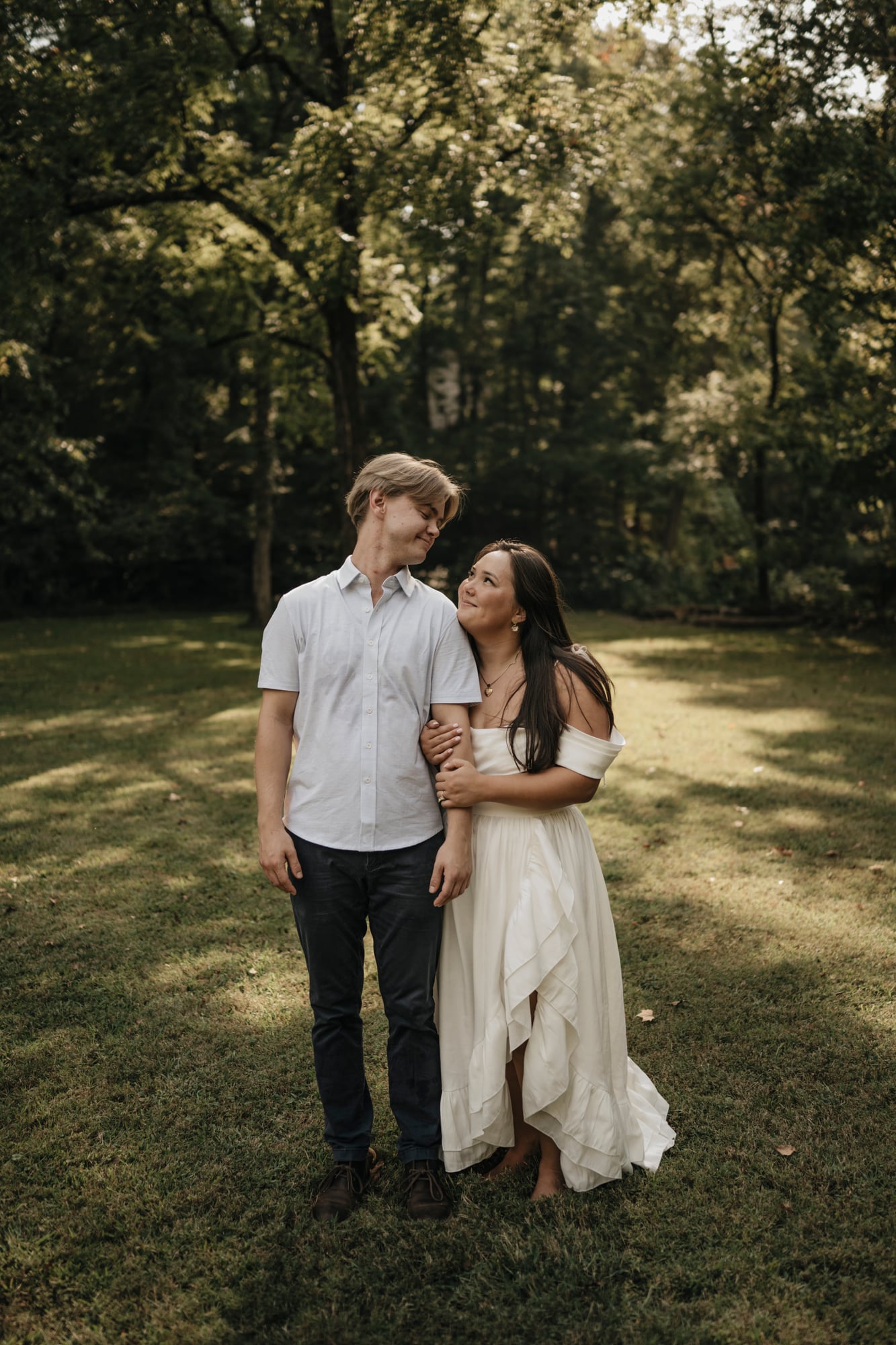 Couple standing together in a sunlit meadow