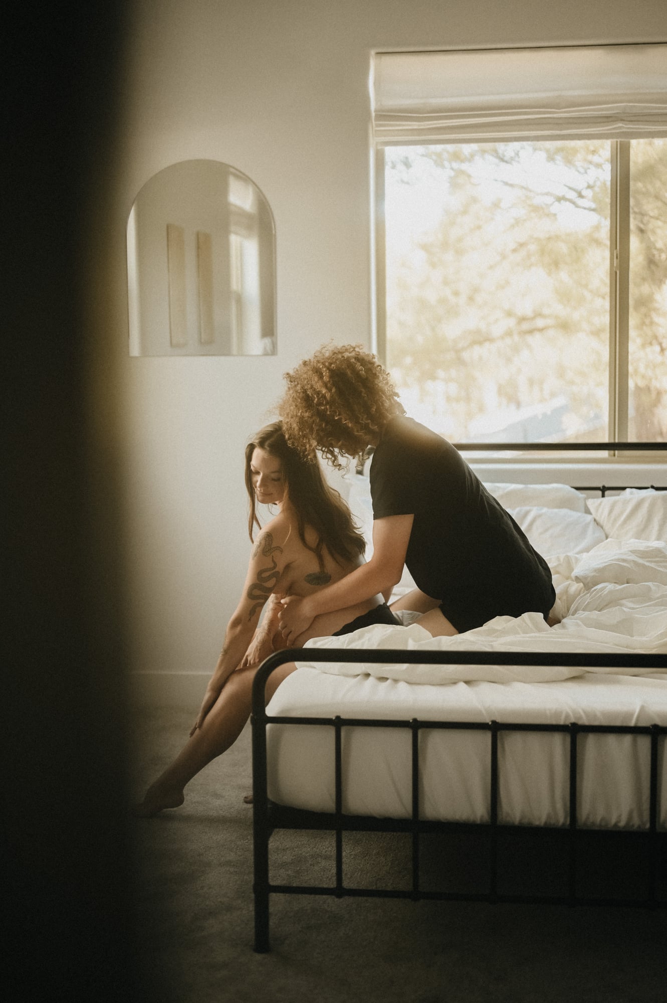Couple sharing a quiet moment on a bed in a bright Phoenix bedroom